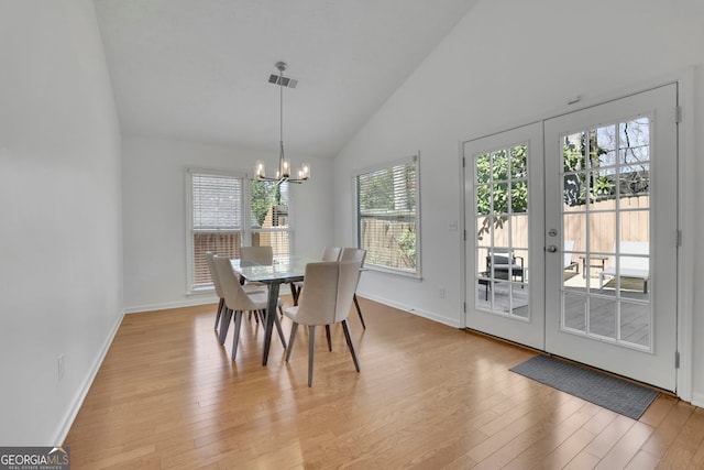 dining space with a notable chandelier, light wood-style floors, visible vents, and french doors