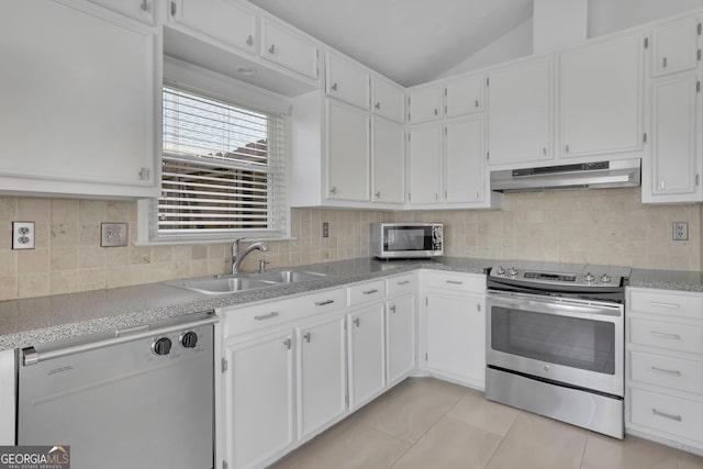 kitchen featuring under cabinet range hood, vaulted ceiling, stainless steel appliances, white cabinetry, and a sink