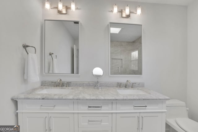 full bathroom with a sink, toilet, double vanity, and a shower stall