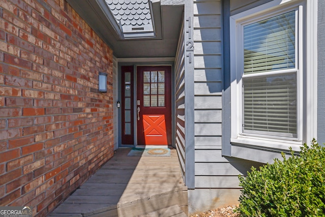 doorway to property featuring brick siding