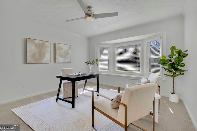 office area featuring baseboards, carpet flooring, a textured ceiling, and a ceiling fan