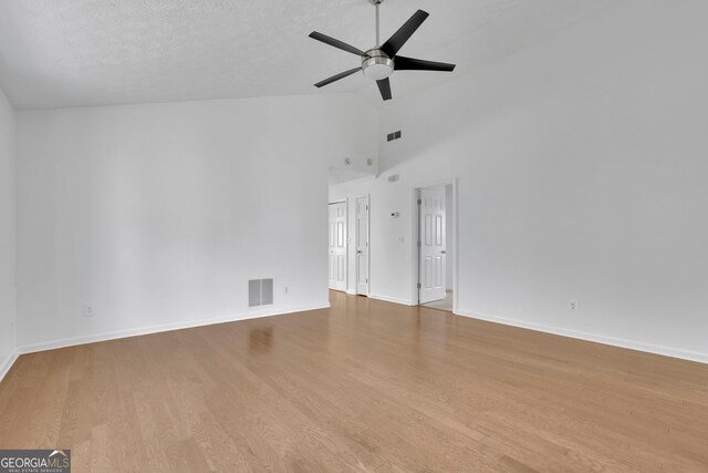 empty room with ceiling fan, visible vents, baseboards, and wood finished floors