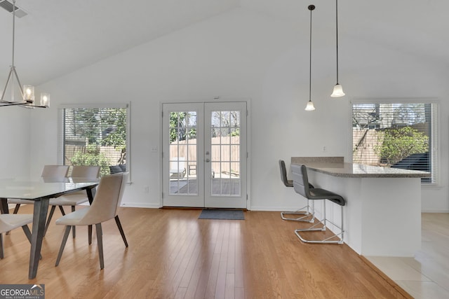 dining room with visible vents, a healthy amount of sunlight, light wood-style flooring, and french doors