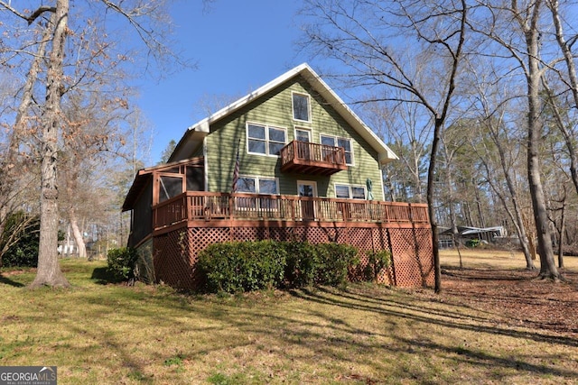 view of front facade with a deck, a front yard, and a balcony