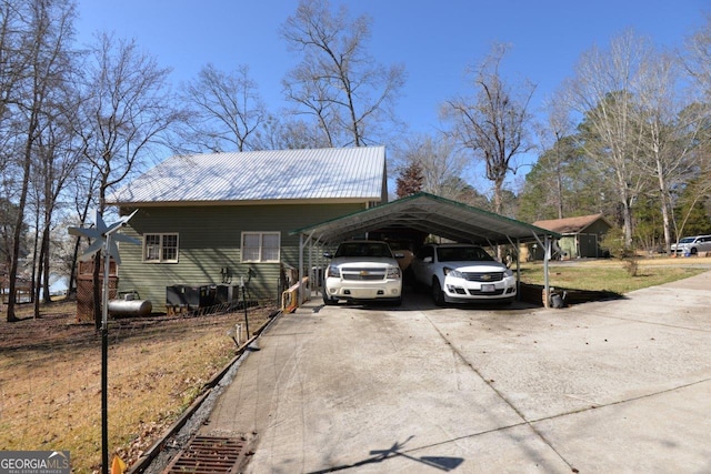 view of property exterior with metal roof, a carport, and driveway