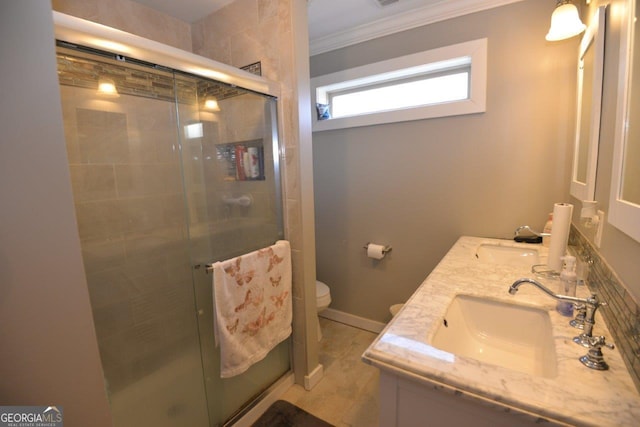 full bathroom featuring a sink, toilet, ornamental molding, and double vanity