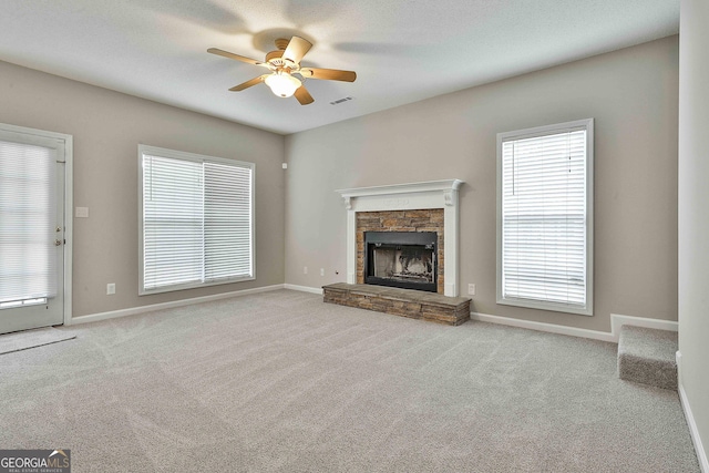 unfurnished living room featuring carpet flooring, visible vents, and a fireplace