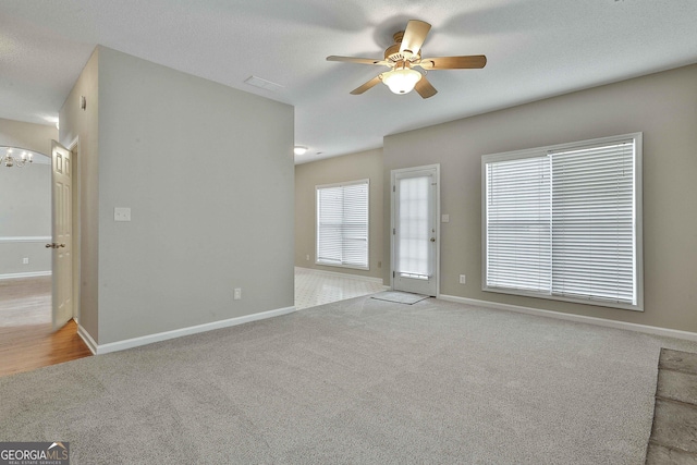 unfurnished living room with visible vents, baseboards, ceiling fan, carpet floors, and a textured ceiling