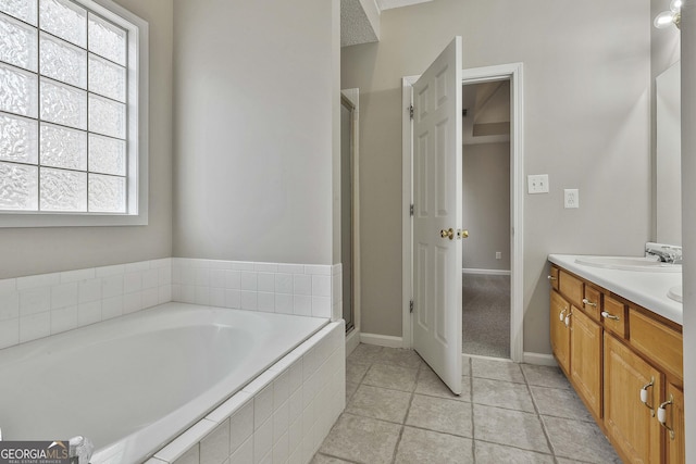 bathroom with double vanity, a shower stall, a garden tub, and a sink