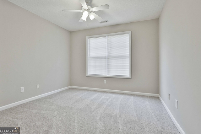 empty room with visible vents, baseboards, carpet flooring, and a ceiling fan