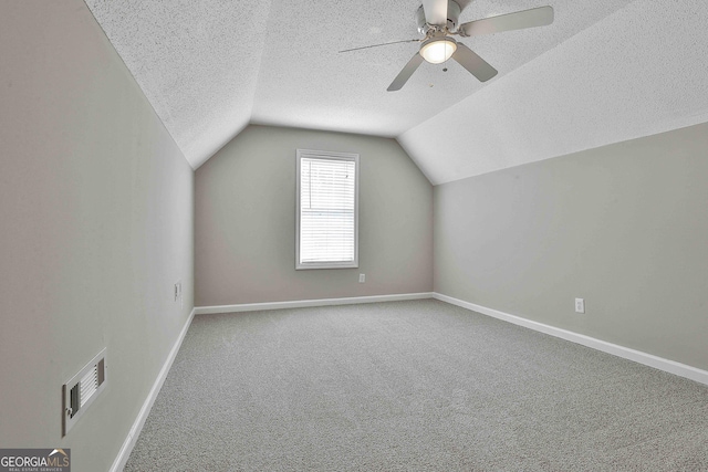 bonus room with visible vents, baseboards, carpet, vaulted ceiling, and a textured ceiling