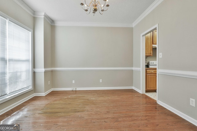 unfurnished dining area featuring light wood-style floors, a healthy amount of sunlight, a chandelier, and ornamental molding