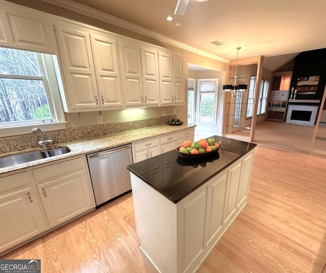 kitchen with dishwasher, white cabinets, light wood-type flooring, and a sink