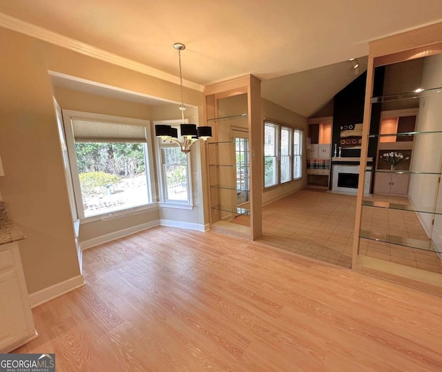 unfurnished dining area featuring light wood-style flooring, a fireplace, baseboards, and a wealth of natural light