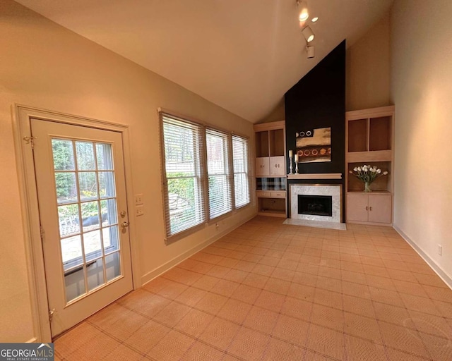 unfurnished living room featuring baseboards, high vaulted ceiling, and a fireplace