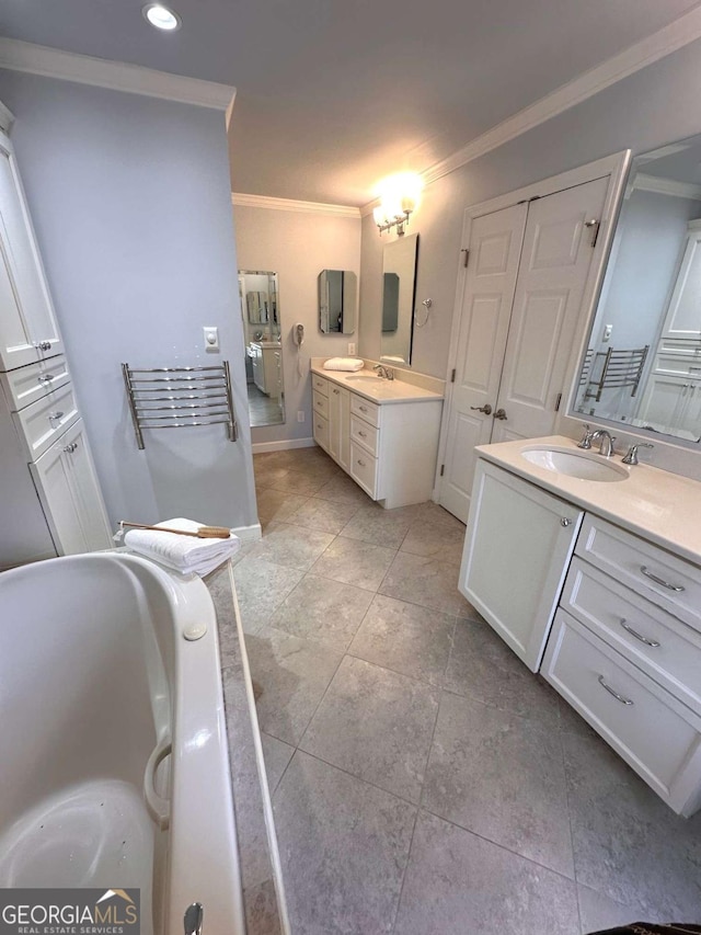 full bathroom featuring two vanities, a bathing tub, crown molding, and a sink