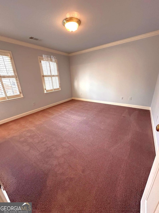 unfurnished room with visible vents, baseboards, carpet, and crown molding