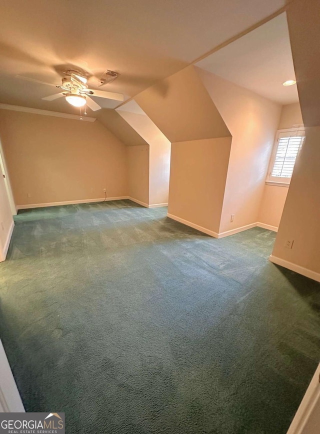 additional living space with lofted ceiling, baseboards, dark colored carpet, and ceiling fan