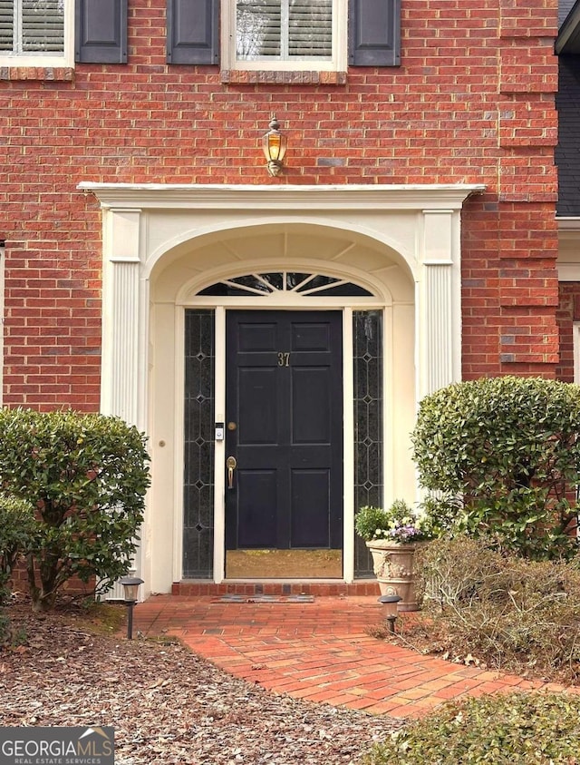 doorway to property featuring brick siding