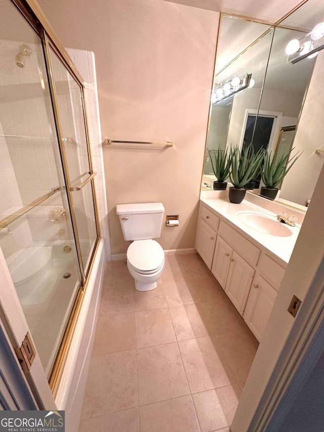 full bath featuring baseboards, toilet, shower / bath combination with glass door, tile patterned floors, and vanity