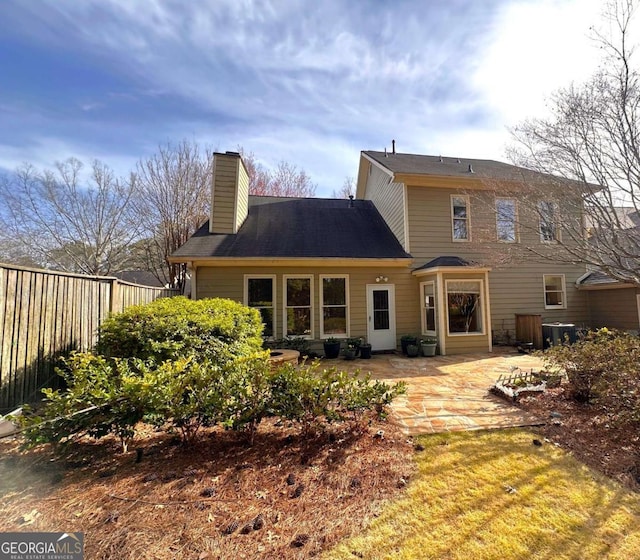 back of property with cooling unit, a chimney, a patio, and fence