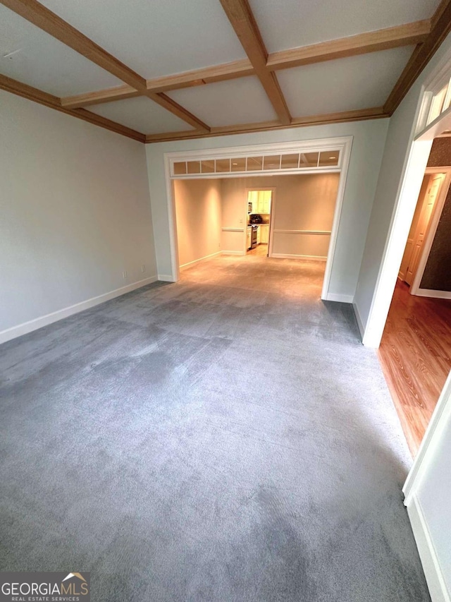 carpeted empty room with baseboards, coffered ceiling, beam ceiling, and ornamental molding