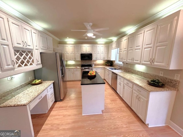 kitchen featuring a center island, crown molding, light wood-style floors, stainless steel appliances, and a sink