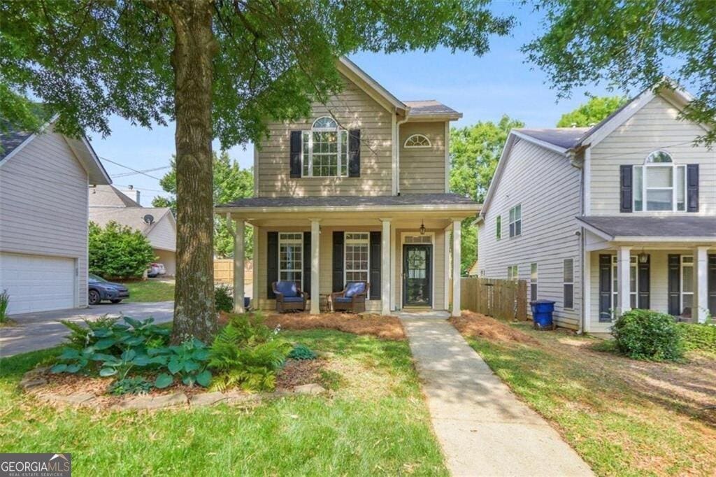 traditional-style house with a porch and fence