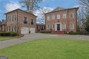 view of front of house featuring aphalt driveway, an attached garage, and a front lawn