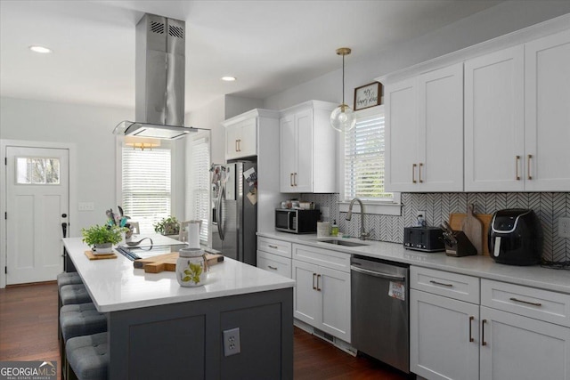 408 Davis St, Monroe, GA 30655 - kitchen with appliances with stainless steel finishes, island range hood, a breakfast bar area, light countertops, and decorative backsplash