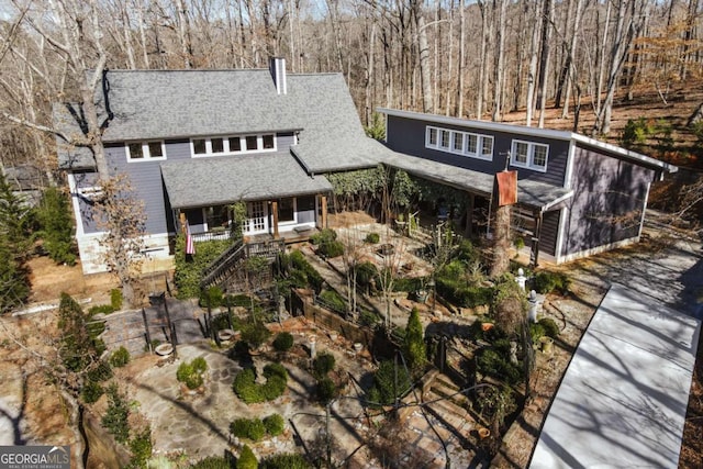 view of front of home with stairway, a porch, and a shingled roof