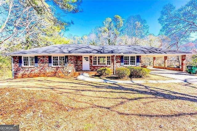 single story home featuring a carport, concrete driveway, and a front lawn