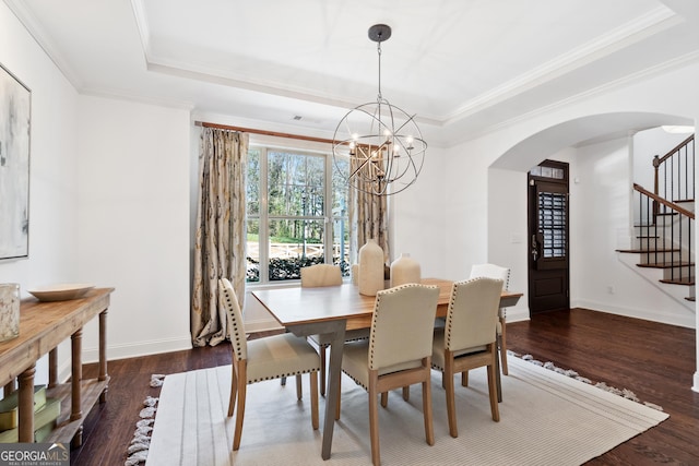 dining area with a tray ceiling, stairway, arched walkways, and a chandelier