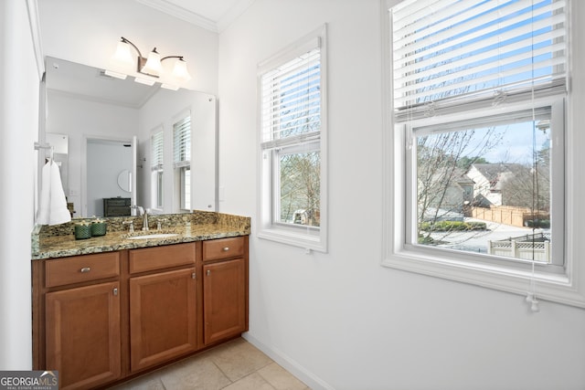 bathroom featuring tile patterned floors, baseboards, ornamental molding, and vanity