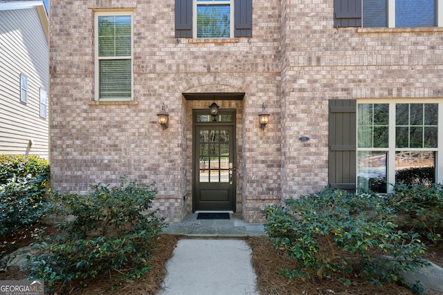 view of exterior entry with brick siding