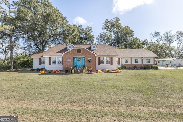 ranch-style home featuring a front yard and brick siding