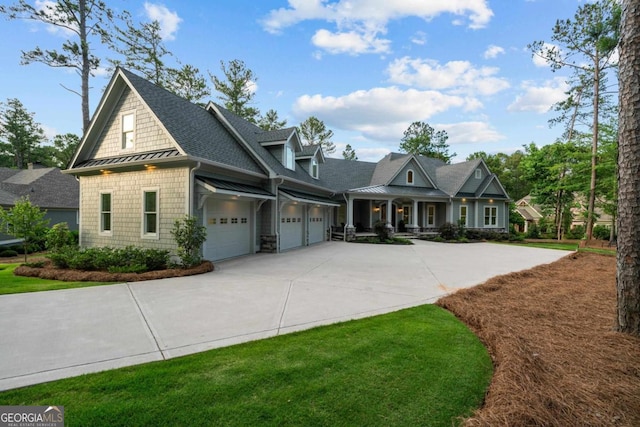 view of front of home featuring driveway, a standing seam roof, a porch, a garage, and metal roof