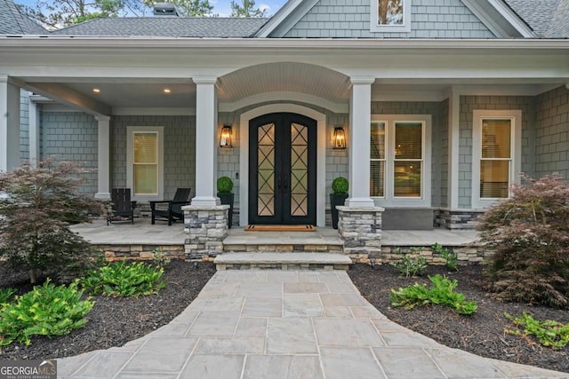 property entrance with a porch and roof with shingles