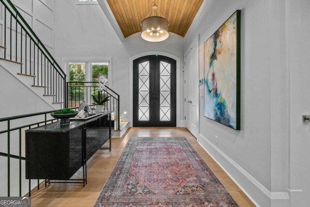 living area featuring beamed ceiling, coffered ceiling, visible vents, and a glass covered fireplace