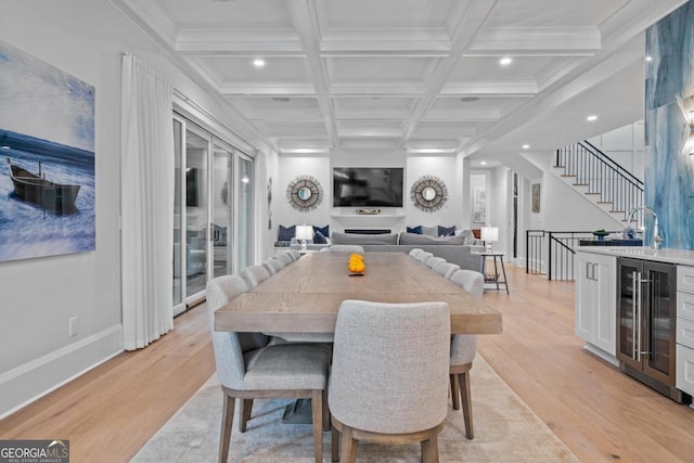 dining area featuring beverage cooler, beamed ceiling, stairway, light wood-style flooring, and coffered ceiling