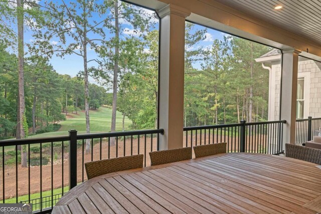 sunroom / solarium featuring a lit fireplace and wooden ceiling