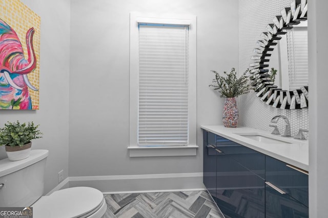 bathroom featuring baseboards, toilet, and vanity