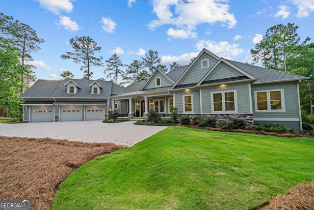 craftsman inspired home with a garage, covered porch, driveway, and a front yard