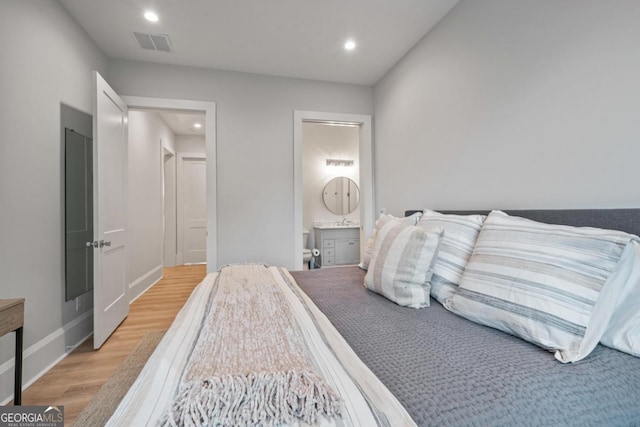 bedroom with visible vents, baseboards, ensuite bath, recessed lighting, and light wood-type flooring