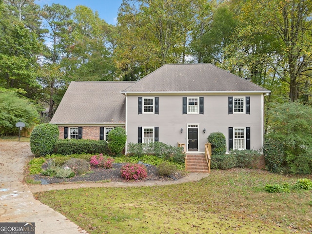 view of front of property with a front yard and roof with shingles