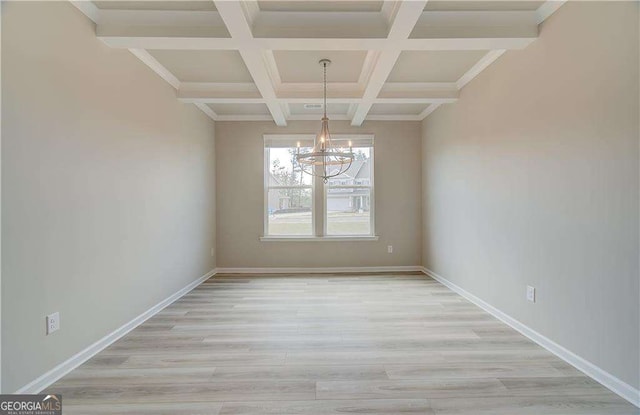 unfurnished dining area with baseboards, coffered ceiling, beam ceiling, light wood-type flooring, and a chandelier