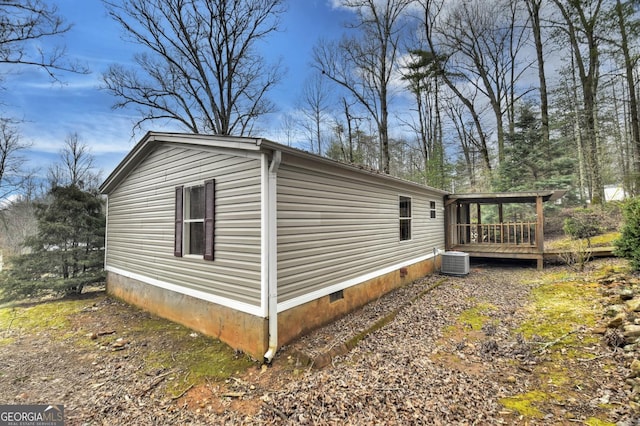 view of side of home featuring crawl space, central AC, and a deck