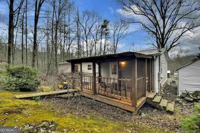 rear view of house featuring metal roof and a wooden deck