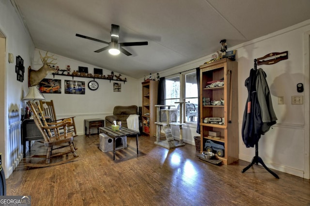 living area featuring a ceiling fan, lofted ceiling, wood finished floors, and baseboards