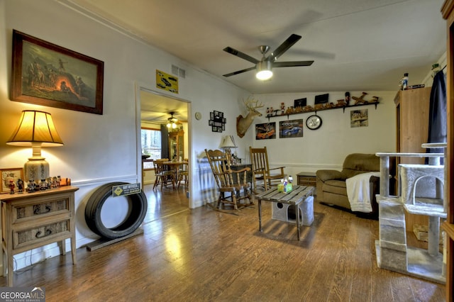 living area with visible vents, lofted ceiling, wood finished floors, and a ceiling fan